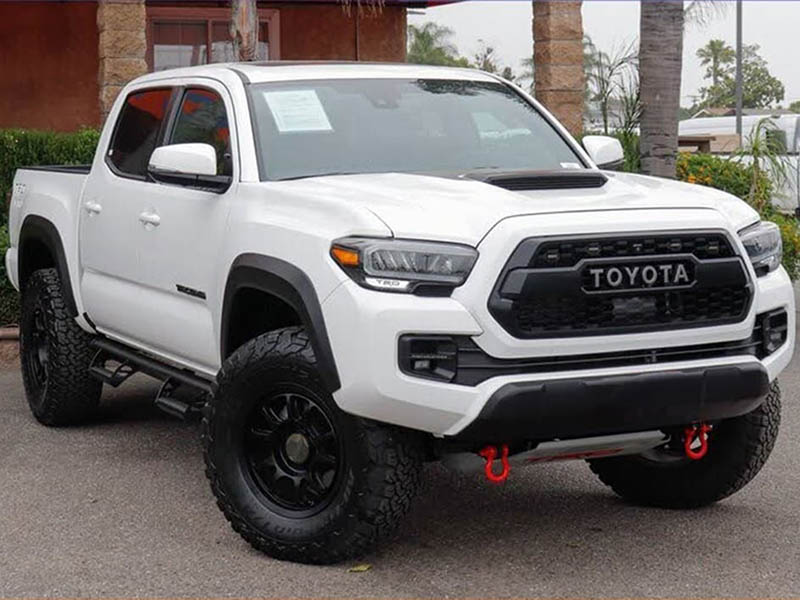 Original white Toyota pickup photographed on a dealership lot.